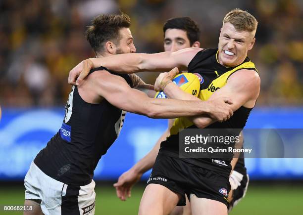 Josh Caddy of the Tigers is tackled by Dale Thomas of the Blues during the round 14 AFL match between the Richmond Tigers and the Carlton Blues at...