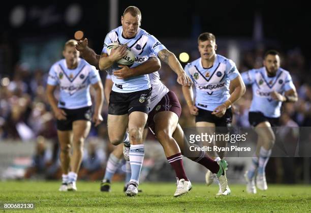 Luke Lewis of the Sharks is tackled during the round 16 NRL match between the Cronulla Sharks and the Manly Sea Eagles at Southern Cross Group...