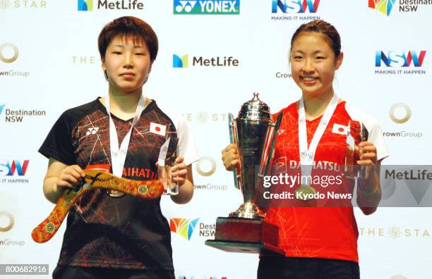 Japan's Nozomi Okuhara and Akane Yamaguchi pose after their final match in the women's singles at the World Super Series Australian Open in Sydney on...