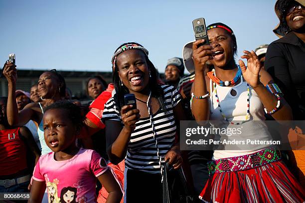 Women take pictures with their mobile phones at a concert on September 23, 2006 in Soweto, Johannesburg, South Africa. The concert was part of Soweto...