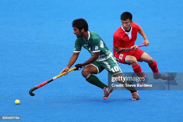 Ali Shan of Pakistan takes the ball away from Zixiang Gou of China during the 7th/8th place match between Pakistan and China on day nine of the Hero...