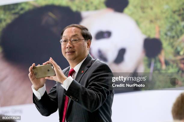 Chinese Ambassador to Germany Shi Mingde takes pictures with his phone at the arrival of panda couple Meng Meng and Jiao Qing at the cargo terminal...