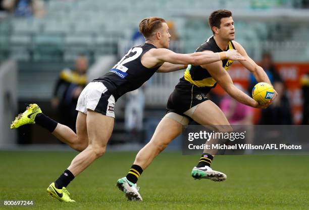 Trent Cotchin of the Tigers and Nick Graham of the Blues in action during the 2017 AFL round 14 match between the Richmond Tigers and the Carlton...