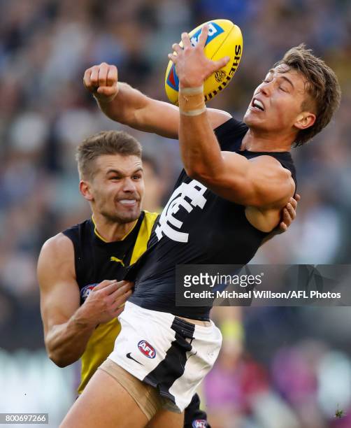 Patrick Cripps of the Blues is tackled by Dan Butler of the Tigers during the 2017 AFL round 14 match between the Richmond Tigers and the Carlton...