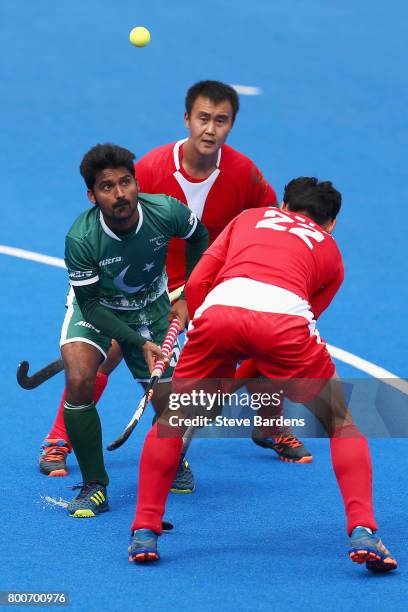 Muhammad Dilber of Pakistan attempts to control the ball while under pressure from Wei Wo of China and Talake Du of China during the 7th/8th place...