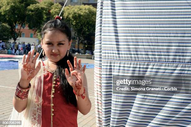 Girl shows her hands painted with henna in Torpignattara, a multiethnic suburb of Rome, during the prayer of Eid al-Fitr which marks the end of the...