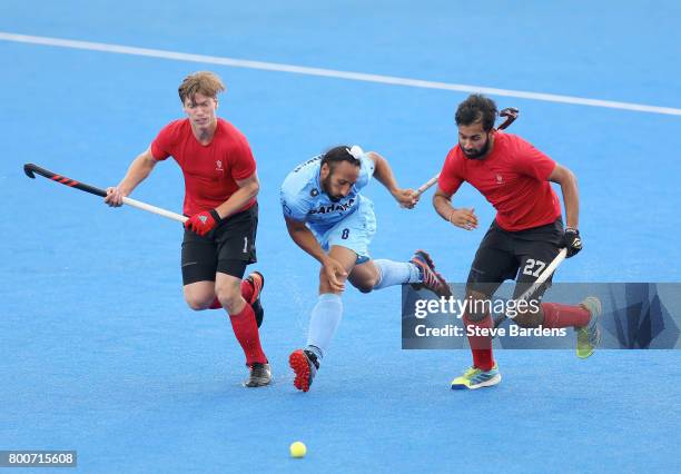 Sardar Singh of India battles for possession with Foris Van Son of Canada and Sukhi Panesar of Canada during the 5th/6th place match between India...