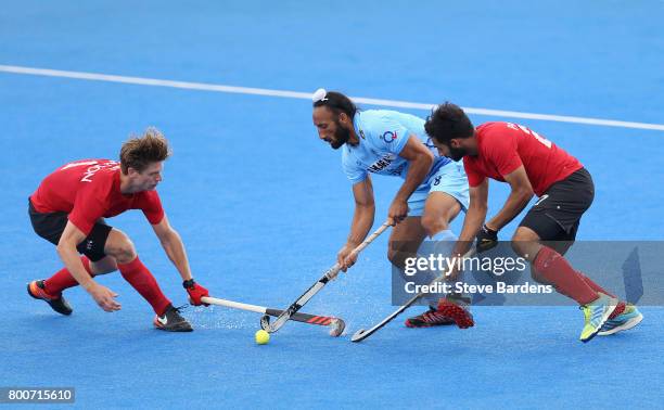 Sardar Singh of India battles for possession with Foris Van Son of Canada and Sukhi Panesar of Canada during the 5th/6th place match between India...