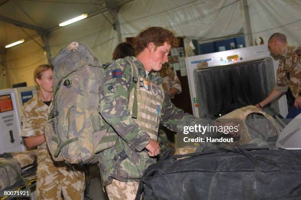 In this handout photo from the British Ministry of Defense , Prince Henry of Wales checks in his bags with the RAF Police at Kandahar Air field Air...