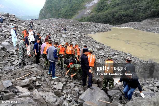 Rescuers work on the site of a massive landslide where over 120 villagers are estimated buried in the early morning disaster on June 24, 2017 in...