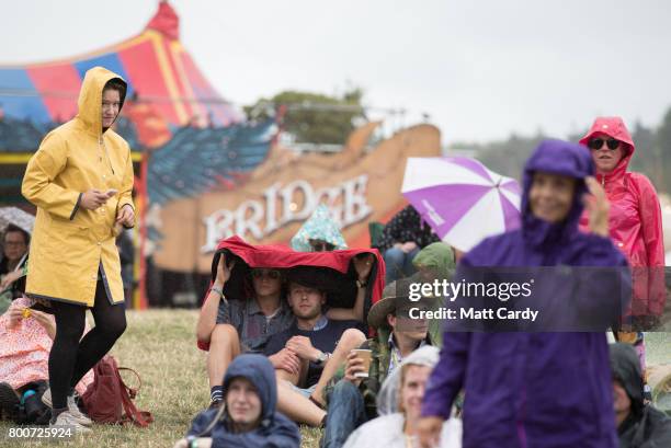 People shelter from the rain at the Glastonbury Festival site at Worthy Farm in Pilton on June 25, 2017 near Glastonbury, England. Glastonbury...