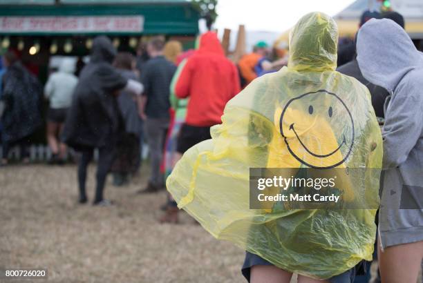 People queue in the rain at the Glastonbury Festival site at Worthy Farm in Pilton on June 25, 2017 near Glastonbury, England. Glastonbury Festival...