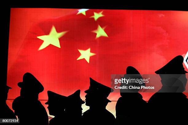 Security guard walk past the Chinese national flag at the Military Museum of Chinese People's Revolution on March 1, 2008 in Beijing, China. From...