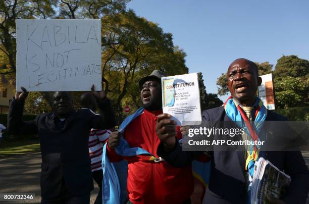 Anti-President Kabila protestors shout slogans and wave placards as they demonstrate near the entrance to Sefako Makgatho Presidential Guest House in...