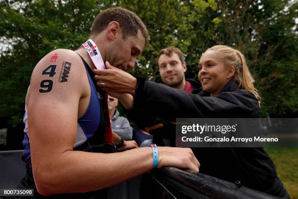 Third pace athlete Oliver Burrows from Great Britain receives the Ironman medal form a relative at the finish line during the Ironman 70.3 UK Exmoor...