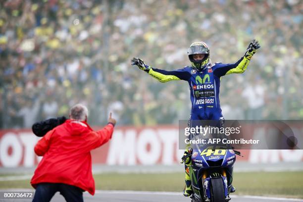 Italy's Valentino Rossi celebrates after winning the Assen Motorcycling Grand Prix at the TT circuit in Assen on June 25, 2017. / AFP PHOTO / ANP /...