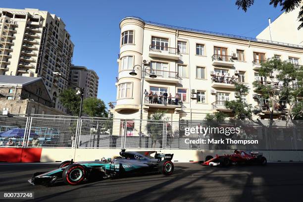 Lewis Hamilton of Great Britain driving the Mercedes AMG Petronas F1 Team Mercedes F1 WO8 leads Sebastian Vettel of Germany driving the Scuderia...