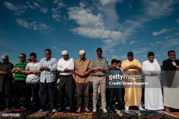 Muslim men participate in a group prayer service during Eid al-Fitr, which marks the end of the Muslim holy month of Ramadan, in Bensonhurst Park in...