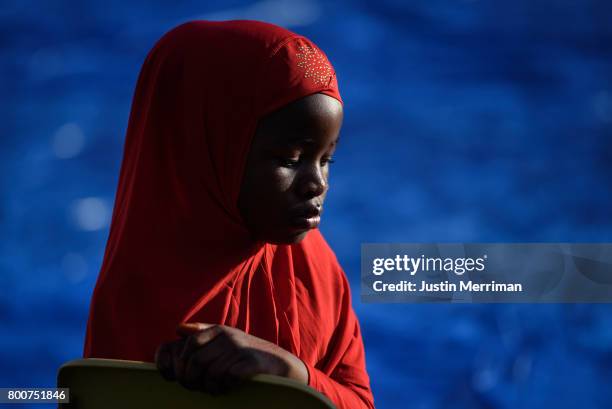 Eheze Hassani of Sharpsburg, Pennsylvania, waits for the prayer to begin during an Eid al-Fitr celebration, which marks the end of Ramadan, on June...