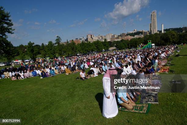 With the University of Pittsburgh's Cathedral of Learning seen in the background, hundreds of Muslims gather in prayer to celebrate Eid al-Fitr,...