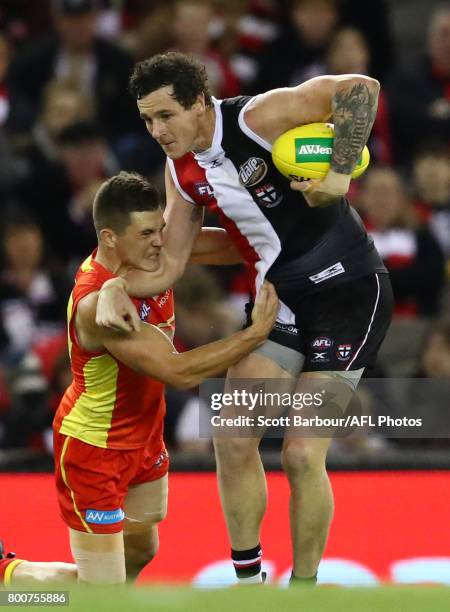 Jake Carlisle of the Saints is tackled during the round 14 AFL match between the St Kilda Saints and the Gold Coast Suns at Etihad Stadium on June...