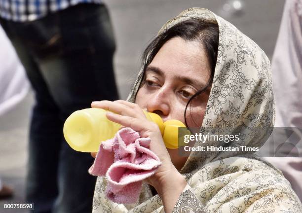 Devotee drinks water during a procession of Lord Jagannath Ratha Yatra, chanting Hare Krishna Maha Mantra, at Sushant Lok, on June 25, 2017 in...
