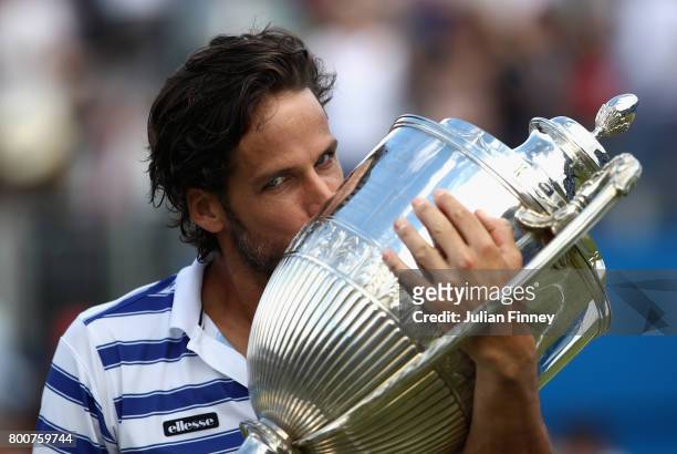 Feliciano Lopez of Spain celebrates with the winners trophy following victory in the mens singles final against Marin Cilic of Croatia during day...