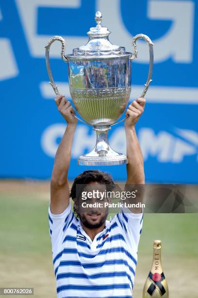 Feliciano Lopez of Spain lifts the trophy after victory during the Final match against Marin Cilic of Croatia on day seven at Queens Club on June 25,...