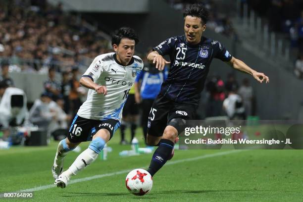 Tatsuya Hasegawa of Kawasaki Frontale and Jungo Fujimoto of Gamba Osaka compete for the ball during the J.League J1 match between Gamba Osaka and...