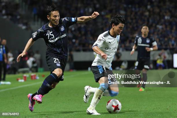 Tatsuya Hasegawa of Kawasaki Frontale and Jungo Fujimoto of Gamba Osaka compete for the ball during the J.League J1 match between Gamba Osaka and...