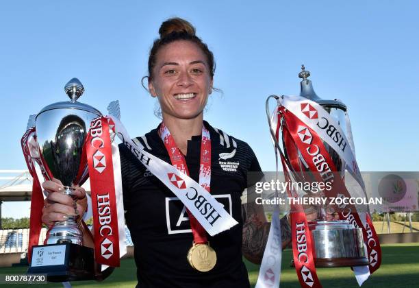 New Zealand's Niall Williams poses with a pair of trophies and her winners medal as she celebrates after her team's victory in the women's rugby...