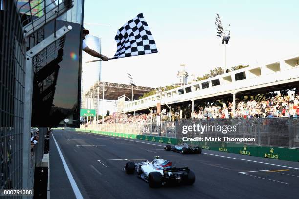 Second place finisher Valtteri Bottas driving the Mercedes AMG Petronas F1 Team Mercedes F1 WO8 crosses the line ahead of third placed Lance Stroll...