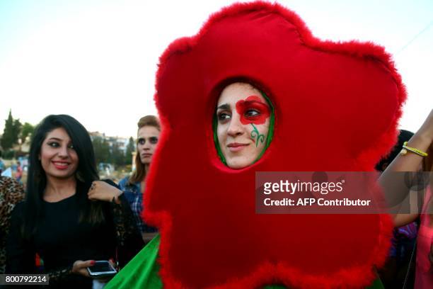 Syrian Kurdish woman takes part in celebrations for Eid al-Fitr holiday, that marks the end of the Muslim fasting month of Ramadan, in the...