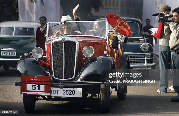 Dr. Vijay Chandra drives a 1937 Morris 8 vintage car as his companion waves after the flag off of 'the 42nd Statesman Vintage & Classic Car Rally...