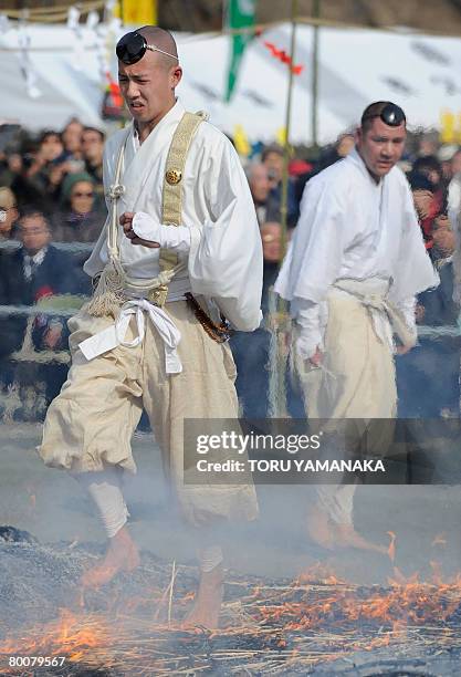 Buddhist monk walks barefoot over fire as he takes part in the traditional "hi-watari", or fire-walking ritual, which heralds the coming of spring at...