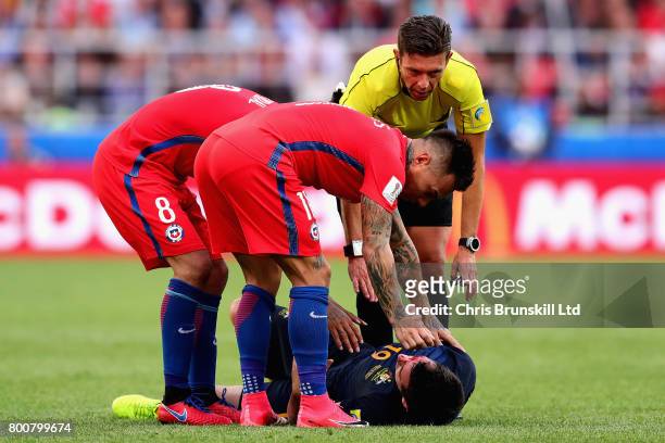 Arturo Vidal of Chile, Eduardo Vargas of Chile and referee Gianluca Rocchi tend to Ryan McGowan of Australia during the FIFA Confederations Cup...
