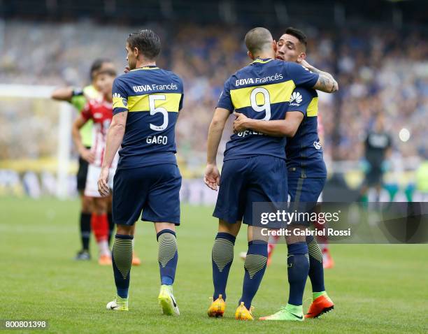 Dario Benedetto of Boca Juniors celebrates with teammates Fernando Gago and Ricardo Centurion after scoring the first goal of his team during a match...
