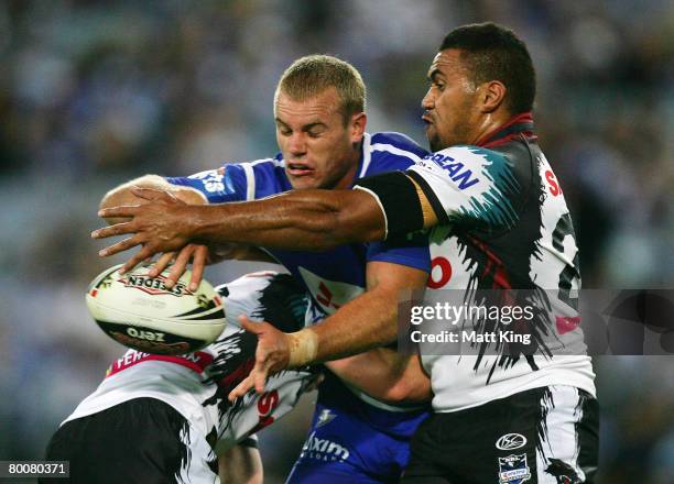 Daniel Holdsworth of the Bulldogs offloads the ball during the NRL trial match between the Bulldogs and the Penrith Panthers at ANZ Stadium on March...