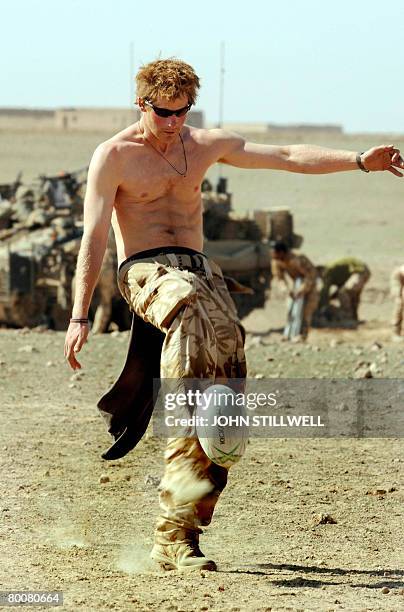 Britain's Prince Harry practices his rugby skills with members of the crew of his Spartan armoured vehicle on February 20, 2008 during a break in...