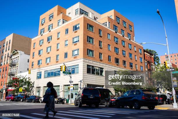 Pedestrians and traffic move past an Internal Revenue Service office building in the East Harlem neighborhood of New York, U.S., on Saturday, June...