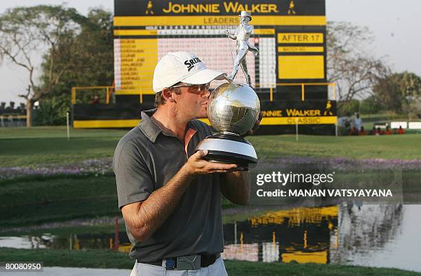 New Zealand golfer Mark Brown kisses his trophy after winning the Johnnie Walker Classic 2008 in Gurgaon on the outskirts of New Delhi on March 2,...