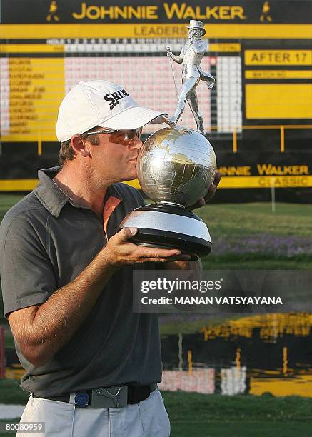 New Zealand golfer Mark Brown kisses his trophy after winning the Johnnie Walker Classic 2008 in Gurgaon on the outskirts of New Delhi on March 2,...