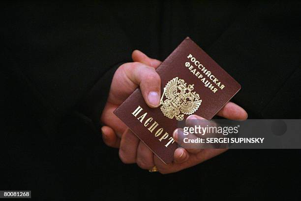 Russian Navy sailor holds his passport while waiting in line to vote at a polling station in Sevastopol, military base of Russian Black Sea Fleet in...