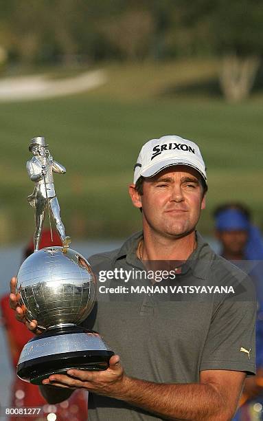 New Zealand golfer Mark Brown poses with his trophy on the eighteenth hole after winning the Johnnie Walker Classic 2008 in Gurgaon on the outskirts...