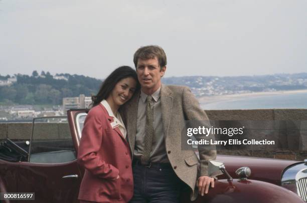 English actor John Nettles who appears in character as Jim Bergerac in the television drama series 'Bergerac', posed together with French actress...