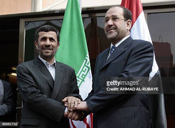 Iranian President Mahmoud Ahmadinejad shakes hands with Iraqi Prime Minister Nuri al-Maliki at the latter's office in Baghdad's heavily fortified...