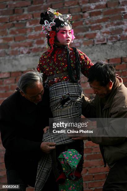 Villagers dress up a child during Shehuo celebrations to mark the starting of spring ploughing and the 2008 Beijing Olympic Games this summer at the...