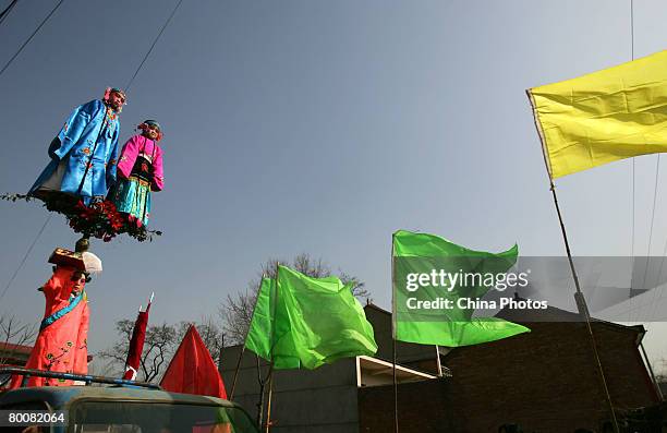 Children dressed as ancient figures stand on a specially designed machinery covered by clothes on a van during Shehuo celebrations to mark the...