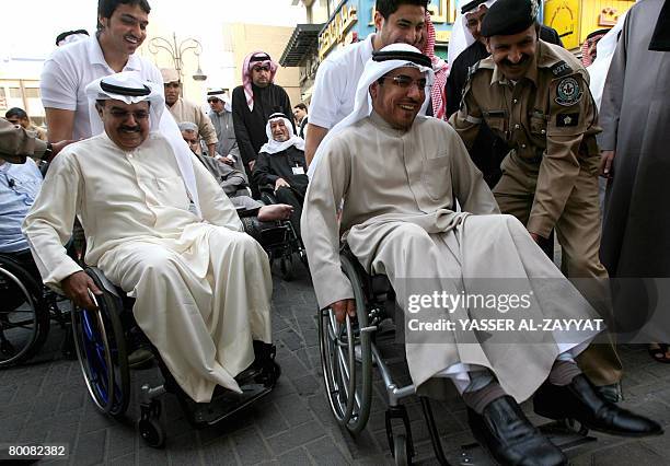 Kuwaiti Health Minister Abdulrahman al-Taweel and Kuwaiti MP Hassan Jawhar use wheelchairs in Mubarakiya market in Kuwait City on March 2, 2008 to...