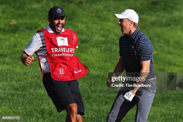 Jordan Spieth of the United States celebrates with caddie Michael Greller after chipping in for birdie from a bunker on the 18th green to win the...